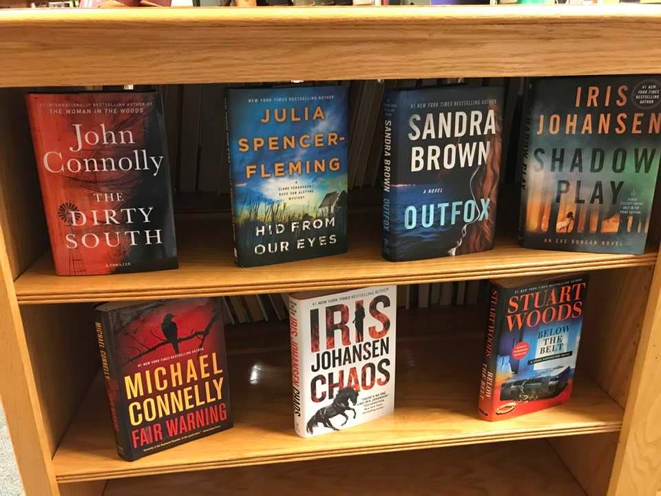 Adult fiction books standing up on a bookshelf